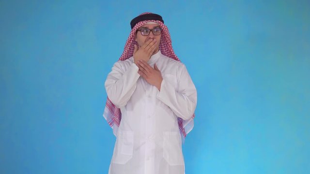 Surprised Arab man stands on blue background