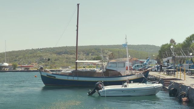 Carvel built wooden sailing boat moored at quite Greek village harbor