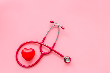 diagnostic and cure of cardiac disease with stethoscope and heart on pink background top view mock-up