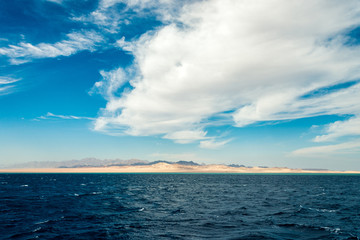Naklejka na ściany i meble Seascape, view of the blue sea with high bald mountains in the background