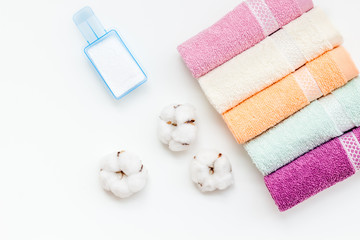 powder for laundry and cotton towels on white background top view