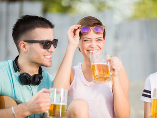 Young and happy couple with beer outdoors