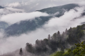 Western Europe mountainous terrain and alpine villages against the backdrop of the ridges bathe in the sea of fog after the rain