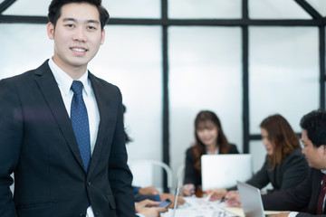 Young businessman standing with tablet near the office window, business concept