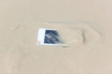 Fototapeta na wymiar White Mobile phone floated to the sea at the beach.