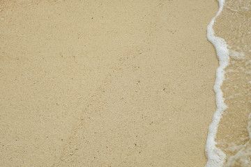 wave of blue ocean on sandy beach with copy space & design for Background