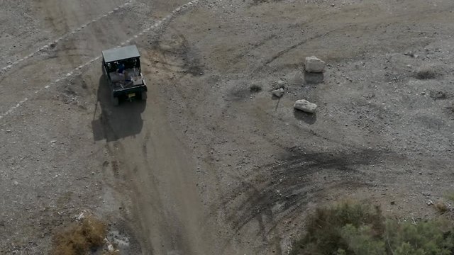 Buggy drive on a trail in a desert park, aerial footage following the buggy