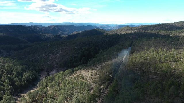 Aerial drone view of the Chepe Train moving through forest in Copper Canyon, Chihuahua, Mexico