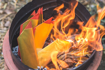 Closeup burning Joss paper or Hell Bank Note for ancestors in Chinese new year or Tomb Sweeping Day.