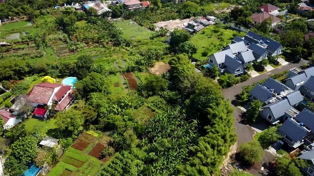 Bird's eye view of a neighborhood in South Jakarta. From above, you can see suburban development in contrast with rice fields in the outskirts of Indonesia's capital.