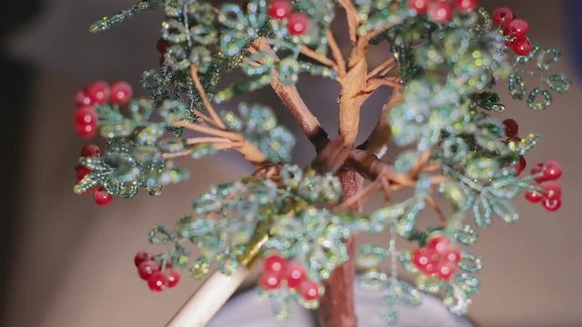 Female artist is painting the handmade wire tree before varnish process