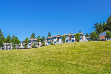 Fototapeta na wymiar Row of new townhouses on top of the hill on sunny day in British Columbia
