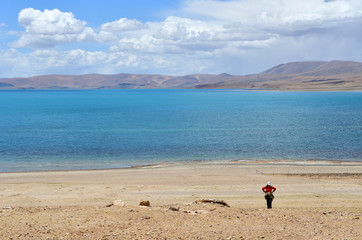 Fototapeta na wymiar Tibet, China. Traveler on the shore of lake Gomang in summer