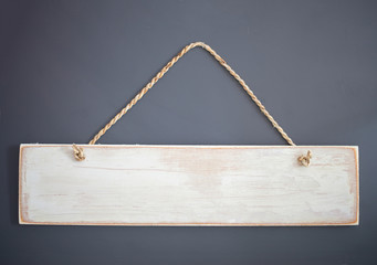 Vintage wooden sign with rope hanging on a gray background