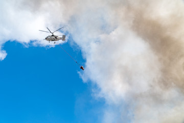 Rescue helicopter drops water extinguishes the fire