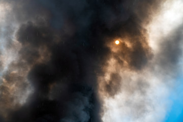 Fototapeta na wymiar Thick black acrid smoke on the sky background