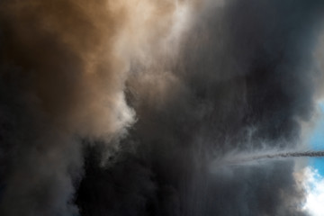 Fototapeta na wymiar Thick black acrid smoke on the sky background