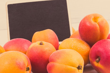 Fresh apricot as healthy snack or dessert containing vitamins. Copy space for text on black board