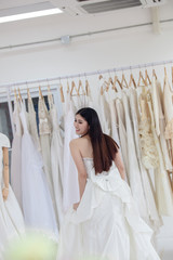 Asian bride trying on wedding dress. Female on wedding dress
