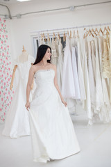 Fototapeta premium Asian bride trying on wedding dress. Female on wedding dress