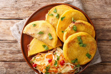 Delicious vegetarian fried Pupusas served with coleslaw close-up on a plate. horizontal top view
