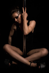 Fototapeta na wymiar Erotica and dance. Sexy dancer posing with pylon on black background