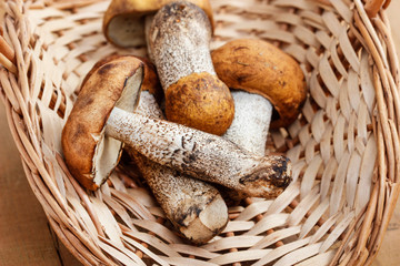 Basket of mushrooms on wooden table.