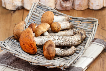 Basket of mushrooms on wooden table.