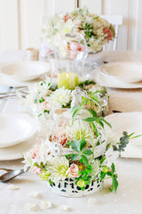 Floral arrangement with roses, dahlias and iris flowers inside a vintage bird cage.