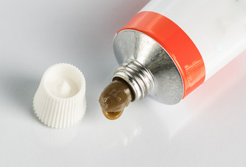 ointment for external use a little squeezed out of a tube on a white background, near the cover