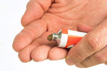 ointment for external use a little squeezed out of a tube on a white background, near the cover