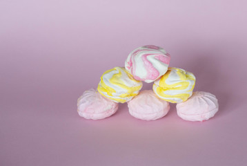 colorful marshmallows - zephyrs on pink background. Colorful meringues on pink. Many sweet zephyrs. Trendy top view dessert image.