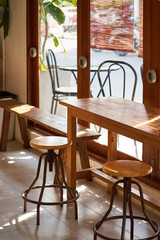 Fototapeta na wymiar Sunshine to Wooden table and chairs beside the glass doors. 