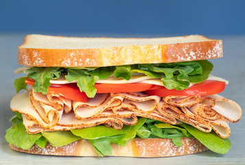 Freshly made deli style sandwich with lettus, several different kinds of vegetables, tomatoes, cheese, meats similar to ham, chicken or turkey. Great for printed menus, online food 