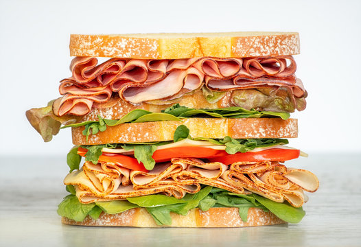 Fresh double layered sandwich with ham, lettuce, tomatoes, cheese on a toast bread. Food background.
