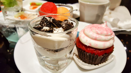 cocktails appetizer that consist of cup cake, melon, water melon on disk in the night party
