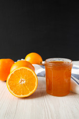 Homemade orange jam in a glass jar, side view. Closeup.