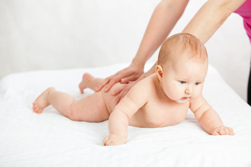 the kid loves a back massage. masseuse doing massage to the baby. child on white isolated background