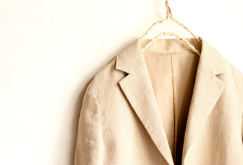 白バックにベージュのジャケットの肩や襟のクローズアップ