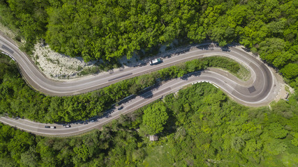 Aerial view of a curved winding road trough the mountains