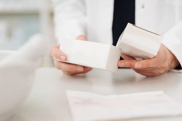 Pharmacist checking two boxes of medication