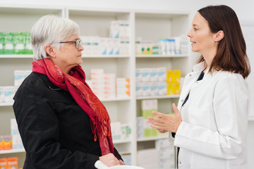 Helpful pharmacist talking to an elderly woman
