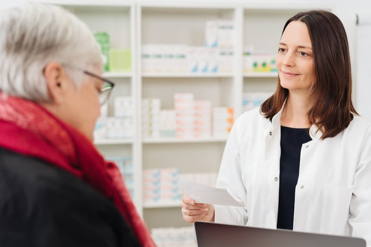 Female pharmacist attending to an elderly woman