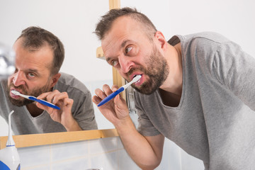 Man brushing his teeth in bathroom