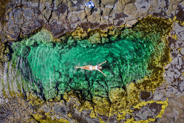 Carefree woman in bikini floating in beautiful rock pool summer Australia - 265753637