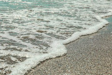Sea sand and foamy water, top view. Summer backdrop