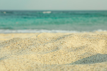 Fototapeta na wymiar Sea sand against blue sea water, space for text. Summer backdrop