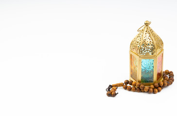 Lantern and rosary beads or tasbih on white background. Selective focus, copy space and Ramadan Kareem concept