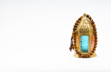 Lantern and rosary beads or tasbih on white background. Selective focus, copy space and Ramadan Kareem concept