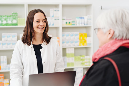 Smiling pharmacist chatting to an elderly lady